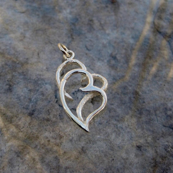 Sterling Silver 2 Hearts Pendant  features an artistic impression of love in which a brushed finish open heart is entwined with a polished heart.