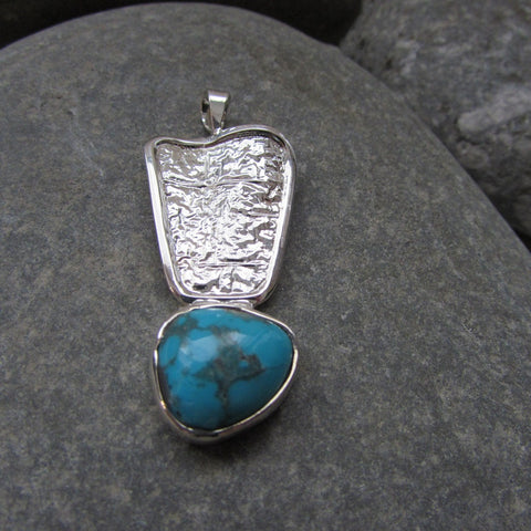 Sterling Silver Aztec Azure Turquoise Pendant Inspired by Aztec motif this pendant features a hammered wave styled plate finished with a natural turquoise gemstone